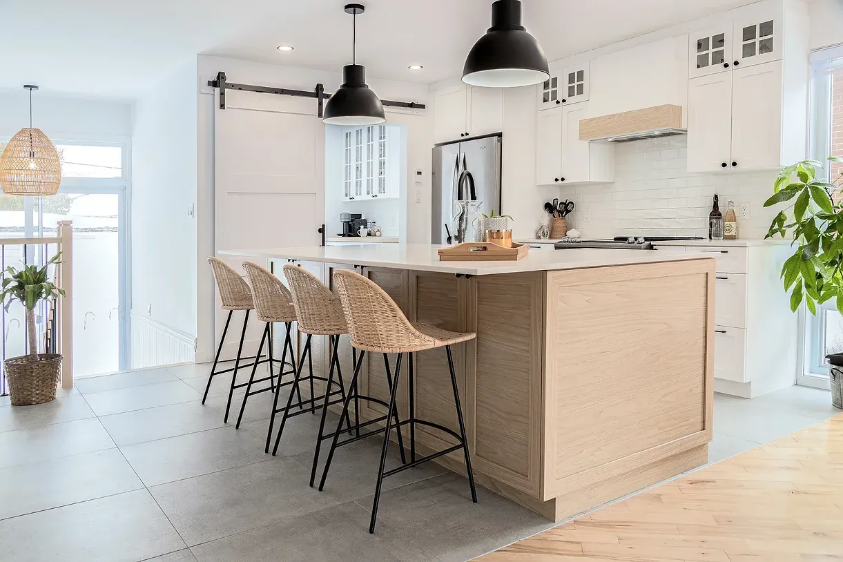Plan de travail en bois clair avec îlot central dans une cuisine contemporaine ouverte.